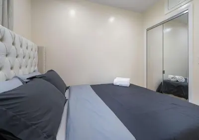 a bedroom with a large bed and a mirror at Amazing Location Murray Hill 3 Bedroom Apartment ,June to Aug 90 days stay required in New York