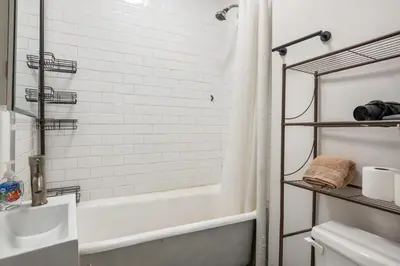 a white bathroom with a tub and a sink at Cozy 2BR in NYC! Lenox Hill!, June to Aug 90 days stay required in New York
