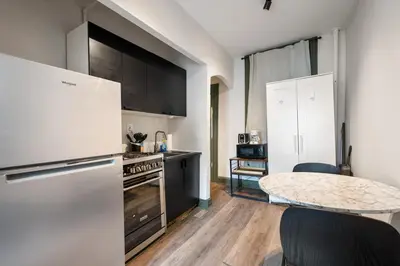 a kitchen with a white refrigerator and a table at Cozy 2BR in NYC! Lenox Hill!, June to Aug 90 days stay required in New York