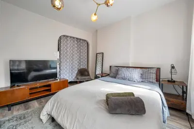 a bedroom with a large bed and a flat screen tv at Cozy 2BR in NYC! Lenox Hill!, June to Aug 90 days stay required in New York