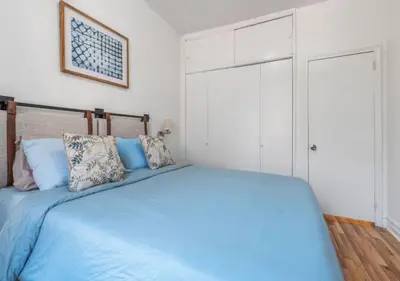 a bedroom with a blue bed and a closet at Chelsea 2BR Gem! in New York