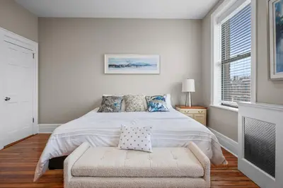 a bedroom with a bed and a chair and a window at Luxury Townhouse in NYC in New York