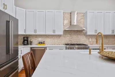 a kitchen with white cabinets and a white counter top at Luxury Townhouse in NYC in New York