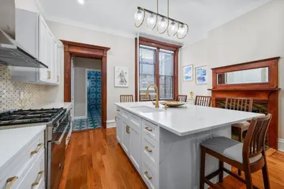 a kitchen with white cabinets and a counter top at Luxury Townhouse in NYC in New York