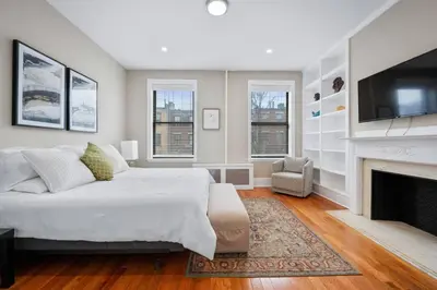 a bedroom with a large bed and a fireplace at Luxury Townhouse in NYC in New York