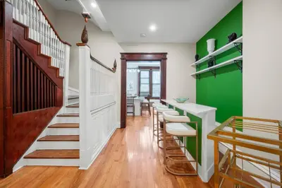 a room with green walls and a row of stools at Luxury Townhouse in NYC in New York