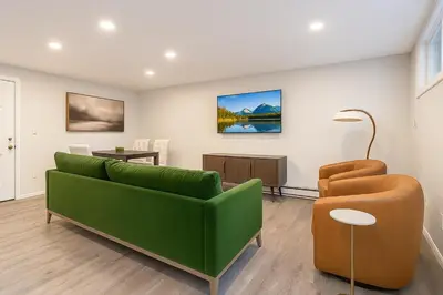 a living room with a green couch and a table at Westville Stay 2BR Near Yale in New Haven