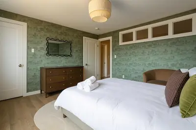 a bedroom with a large white bed and green walls at Westville Stay 2BR Near Yale in New Haven