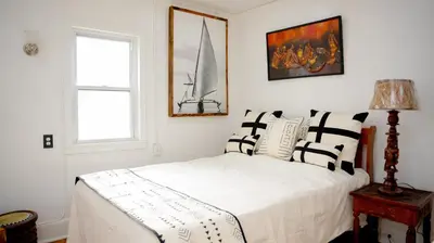 a bedroom with a bed with black and white pillows at African Oasis Luxury Inn at the Gallery in Mount Vernon
