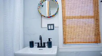 a white sink in a bathroom with a mirror at African Oasis Luxury Inn at the Gallery in Mount Vernon