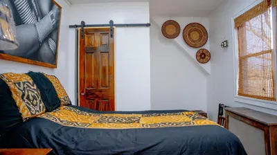a bedroom with a bed with a blue comforter at African Oasis Luxury Inn at the Gallery in Mount Vernon