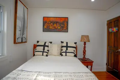 a bedroom with a bed with blue and white pillows at African Oasis Luxury Inn at the Gallery in Mount Vernon