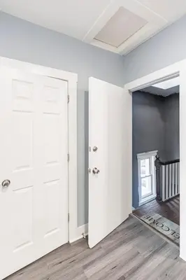 an empty room with white doors and wood floors at Prime Location Explore NYC in West New York