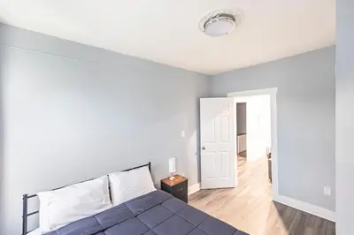 a bedroom with a bed and a white wall at Prime Location Explore NYC in West New York