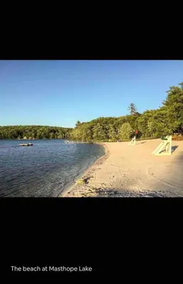 a beach at maszikride lake with a picnic table on the shore at Huge Masthope retreat king sz bed , hot tub , game room in Lackawaxen