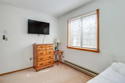 a bedroom with a tv and a dresser and a window at 3 Mi to Tobyhanna State Park Home with Serene Deck! in Tobyhanna