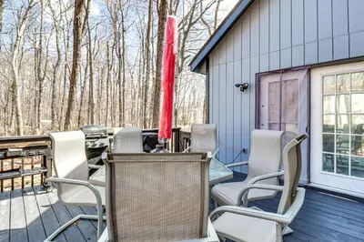 a group of chairs and tables on a deck at 3 Mi to Tobyhanna State Park Home with Serene Deck! in Tobyhanna