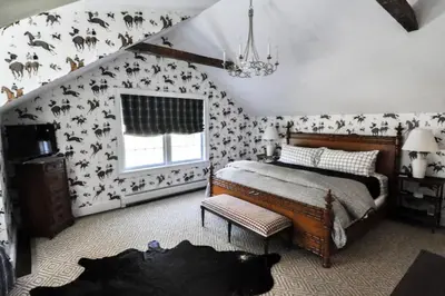 a bedroom with a bed with black and white wallpaper at Haddock Cotter Chic Farmhouse and Barn w Pool in Old Chatham