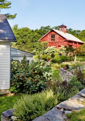 a red house with a garden in front of a house at Haddock Cotter Chic Farmhouse and Barn w Pool in Old Chatham