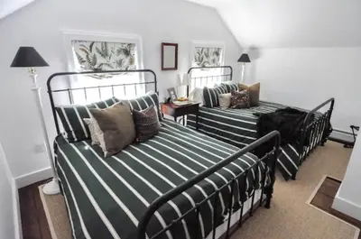 a bedroom with two beds with pillows on it at Haddock Cotter Chic Farmhouse and Barn w Pool in Old Chatham