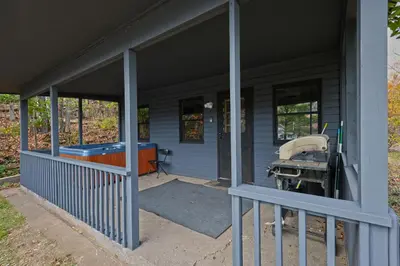 a front porch of a blue house with a tub at Private Hot tub new 2 Bedroom Home in Catskills in Elka Park