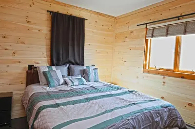 a bedroom with a bed in a log cabin at Private Hot tub new 2 Bedroom Home in Catskills in Elka Park