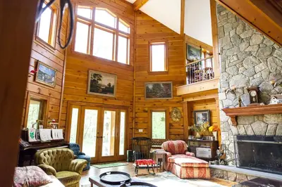 a living room with a fireplace and a stone wall at Lovely Accommodation Surrounded by Stunning Forests in Bedford near New York City in Bedford