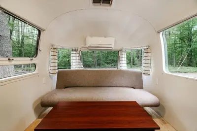 a small room with a chair and a table at Waterfront, Pet Friendly Airstream near Lake George in the Adirondack, New York in Corinth