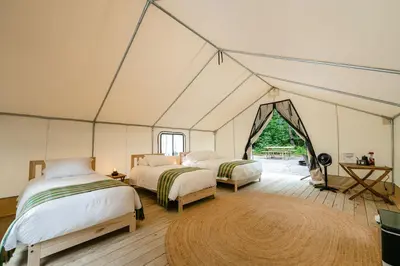 a room with two beds in a tent at Luxury Group Safari Tent Complete with Firepit and Patio, Perfect for a Weekend Escape to the Adirondacks in Corinth