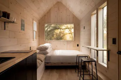 a small bedroom with a bed and a window at Secluded, Dog Friendly Tiny House on the Hudson River, near Saratoga Springs in Corinth