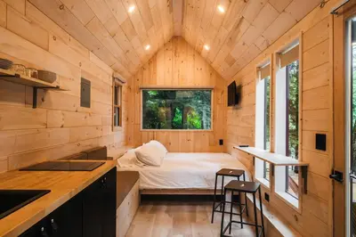 a tiny house with a bed in the middle at Secluded, Dog Friendly Tiny House on the Hudson River, near Saratoga Springs in Corinth