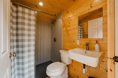 a bathroom with a toilet and a sink at Luxury Canvas Group Glamping Tent | Adirondacks in Corinth, NY in Corinth