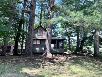 a small house in the middle of some trees at Rustic, Pet Friendly Cabin on the Hudson River, Perfect for a Glamping Weekend in the Adirondacks in Corinth