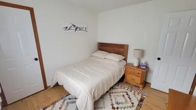 a bedroom with a bed and a table with a lamp at Wilderness Getaway in East Jewett