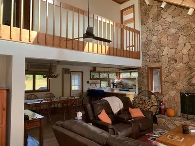 a living room with a couch and a stone wall at Wilderness Getaway in East Jewett
