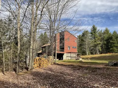 a large red brick house with a stone wall at Wilderness Getaway in East Jewett