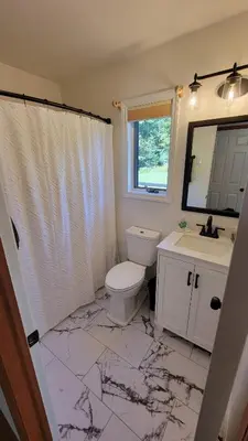 a bathroom with a toilet and a sink and a mirror at Wilderness Getaway in East Jewett