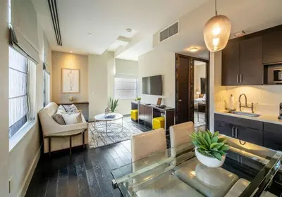 a living room with a glass table and a kitchen at Charming 2BR Apartment Near Times Square in New York
