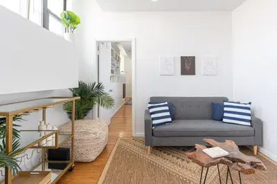 a living room with a couch and a table at Amazing Furnished 1 BR Penthouse Midtown West in New York