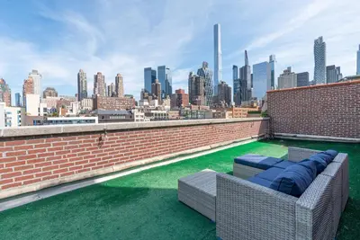 a couch on a rooftop with a view of a city at Amazing Furnished 1 BR Penthouse Midtown West in New York