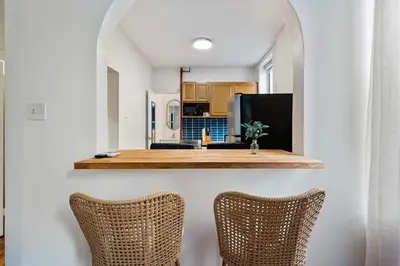 a kitchen with two wicker chairs and a counter at 2BR Upper East Side near Central Park in New York