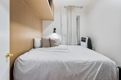 a bedroom with a bed with a white comforter at 2BR Upper East Side near Central Park in New York