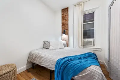 a small bedroom with a bed and a window at 2BR Upper East Side near Central Park in New York