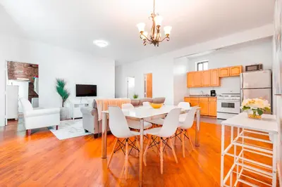 a kitchen and dining room with a table and chairs at Prime Location Upper Manhattan Furnished Apartment in New York