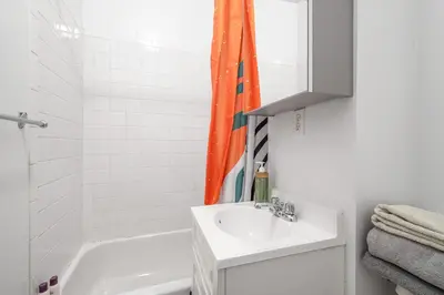 a white bathroom with a sink and a shower at Lovely Apt Near Central Park in New York