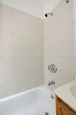 a bathroom with a white tub and a sink at Cozy Studio Steps to Central Park Upper E Side in New York