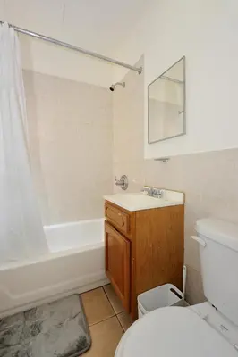a bathroom with a toilet and a tub and a sink at Cozy Studio Steps to Central Park Upper E Side in New York