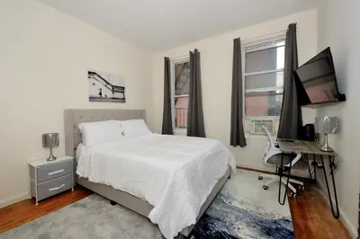 a bedroom with a bed and a desk and a television at Cozy Studio Steps to Central Park Upper E Side in New York