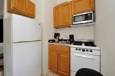 a kitchen with a white refrigerator and a microwave at Cozy Studio Steps to Central Park Upper E Side in New York