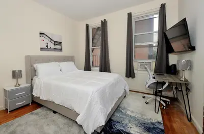 a bedroom with a bed and a desk and a computer at Cozy Studio Steps to Central Park Upper E Side in New York